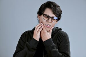 Man holding his jaw in pain needing an emergency dentist in Indianapolis