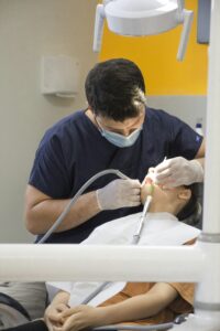 Dentist treating a patient while debunking root canal myths