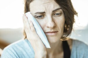 Woman holding her cheek due to tooth sensitivity after a filling